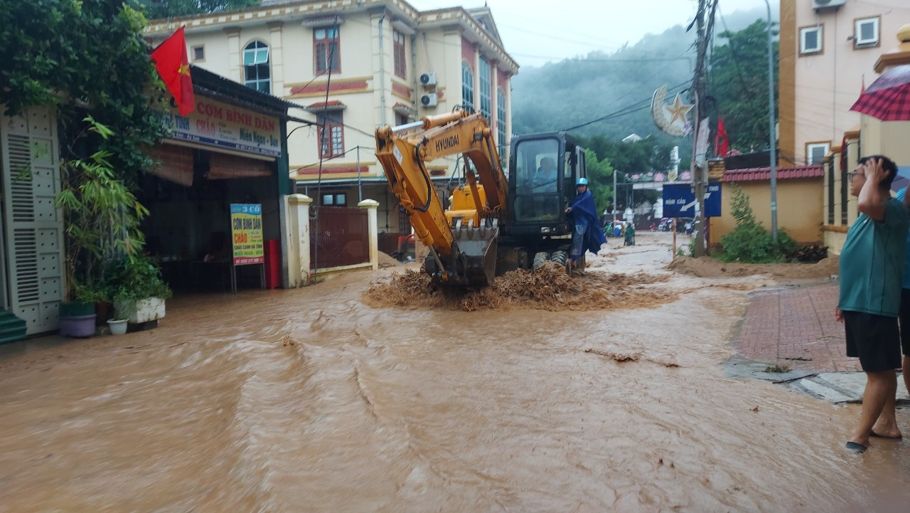Nhiều máy múc được điều động đến hiện trường để khơi thông dòng chảy, tránh tắc gây ngập nhà dân trên địa bàn thị trấn Mường Xén (huyện Kỳ Sơn).
