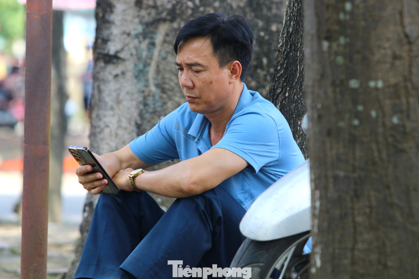 Trong lúc các thí sinh làm bài trong phòng thi, bên ngoài phụ huynh với nhiều trạng thái. Người tranh thủ cập nhật tin tức báo mạng, người ngồi hướng vào cổng trường chờ tin tức của các con.