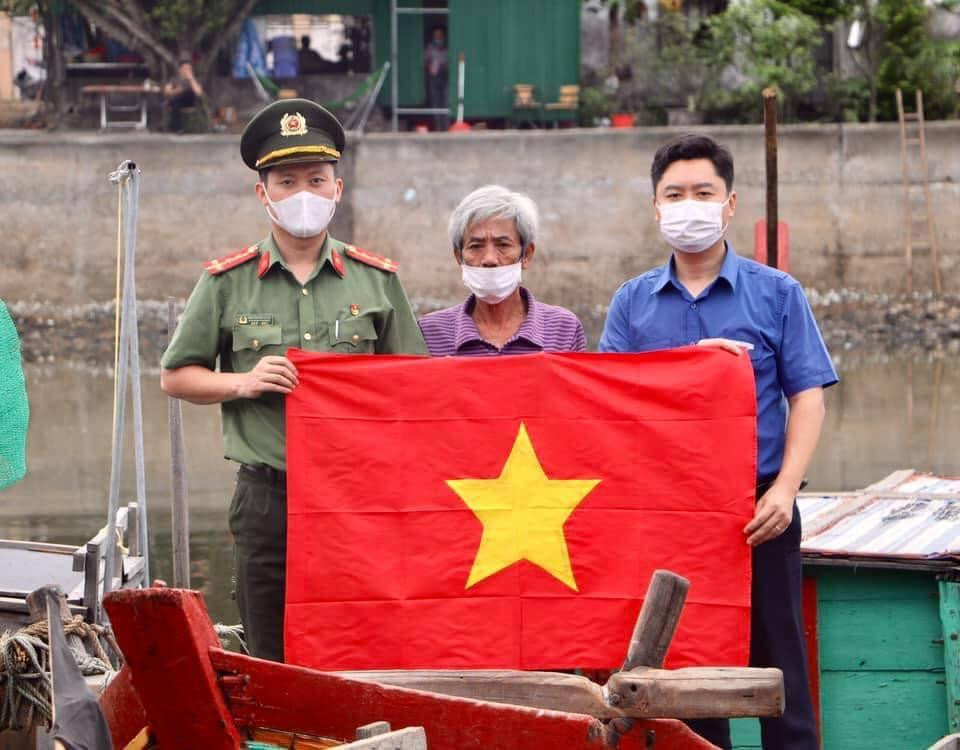 Đoàn Thanh niên Công an tỉnh Nghệ An tặng cờ thi đua cho ngư dân vươn khơi bám biển. Ảnh: Hữu Thăng.