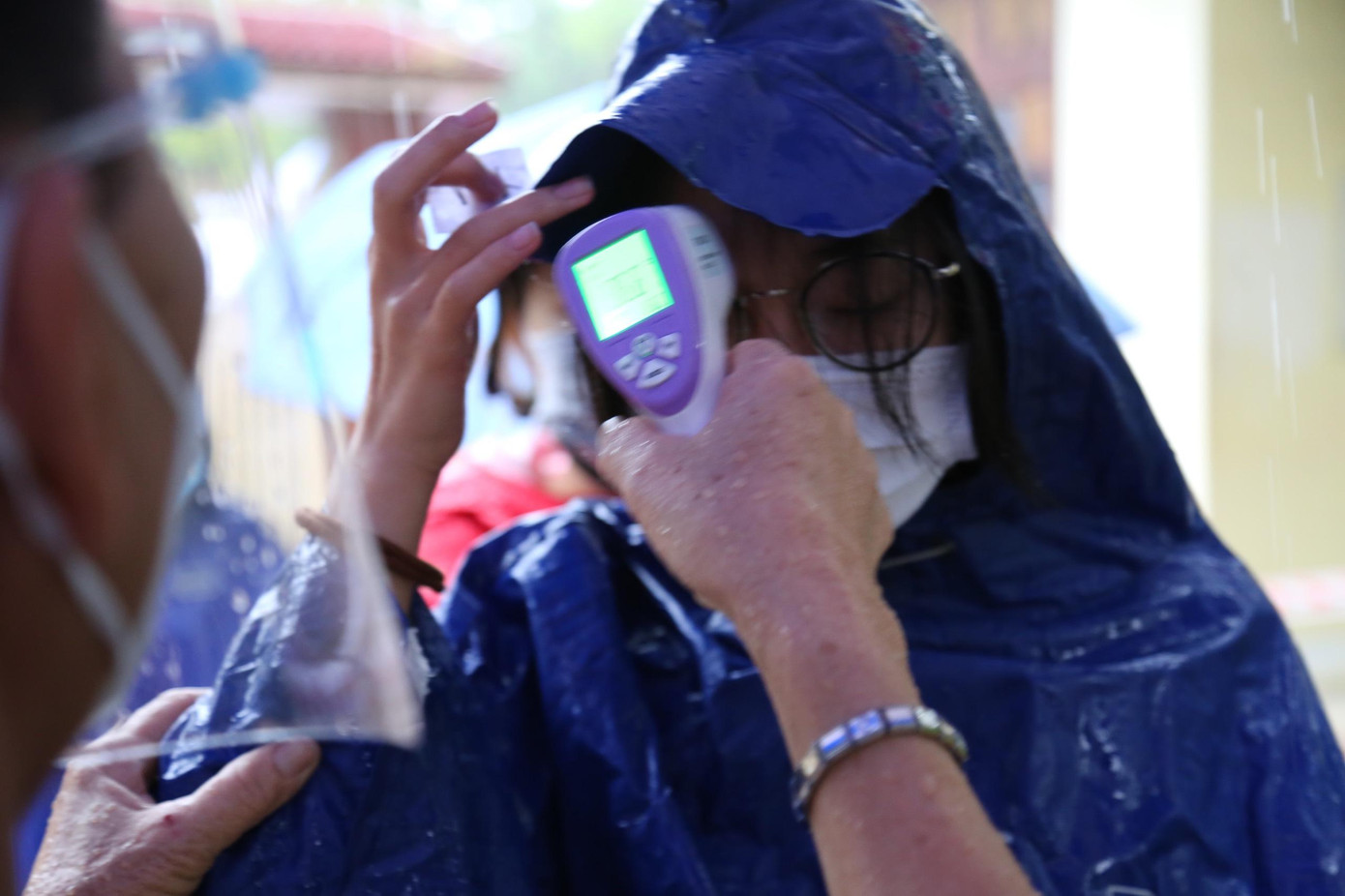 Trước khi vào phòng thi, các thí sinh được nhân viên y tế đo thân nhiệt, thanh niên tình nguyện phân phát khẩu trang, rửa tay sát khuẩn.