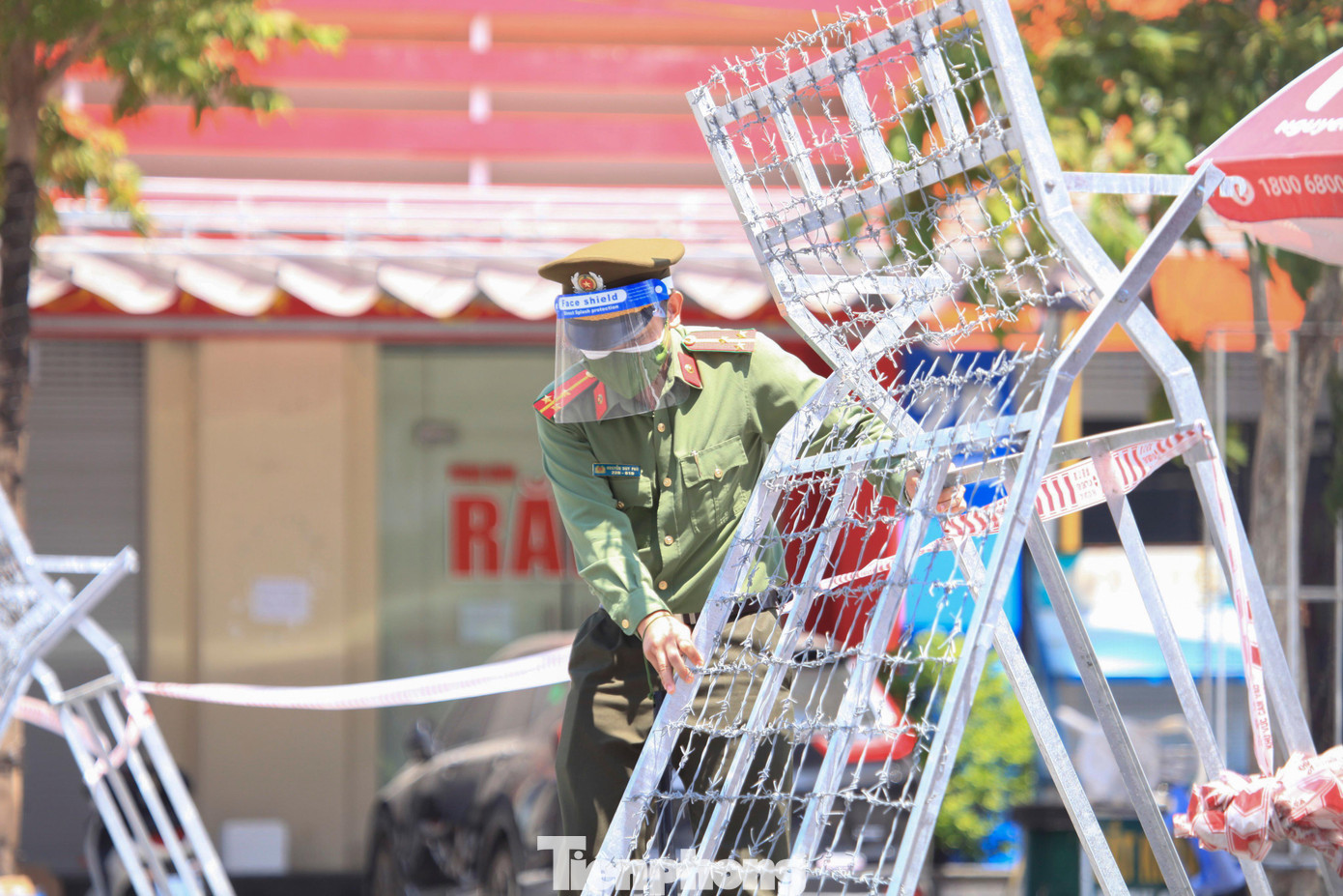 Hơn 100 chốt kiểm soát được thiết lập ở thành phố Vinh để kiếm soát người ra đường, đảm bảo việc giãn cách xã hội được tiến hành nghiêm túc, hiệu quả. Trong ảnh: Thượng úy Nguyễn Duy Phú (Phòng PA03) đang lập hàng rào chắn tại chốt Chợ Vinh.