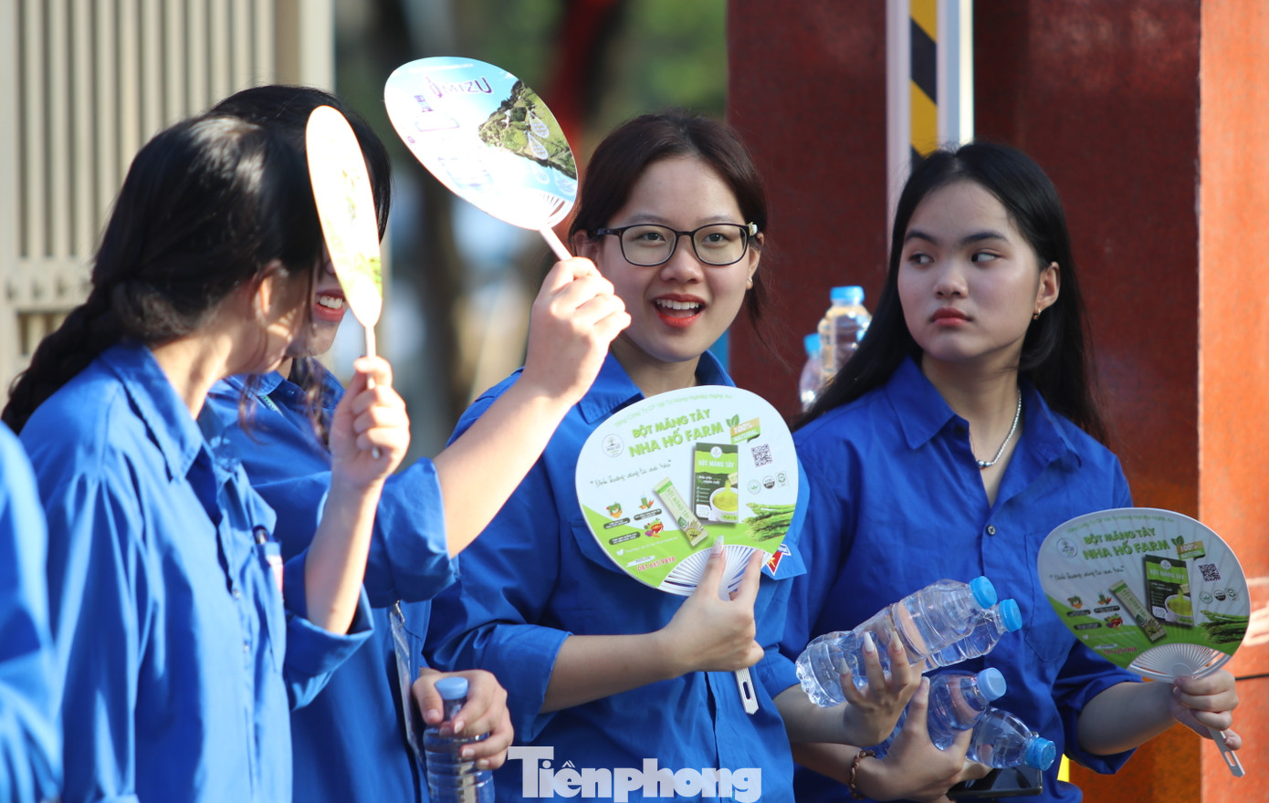 Những cô gái áo xanh trò chuyện trong lúc phát nước tiếp sức cho các sĩ tử ở điểm thi trường THPT chuyên Phan Bội Châu.