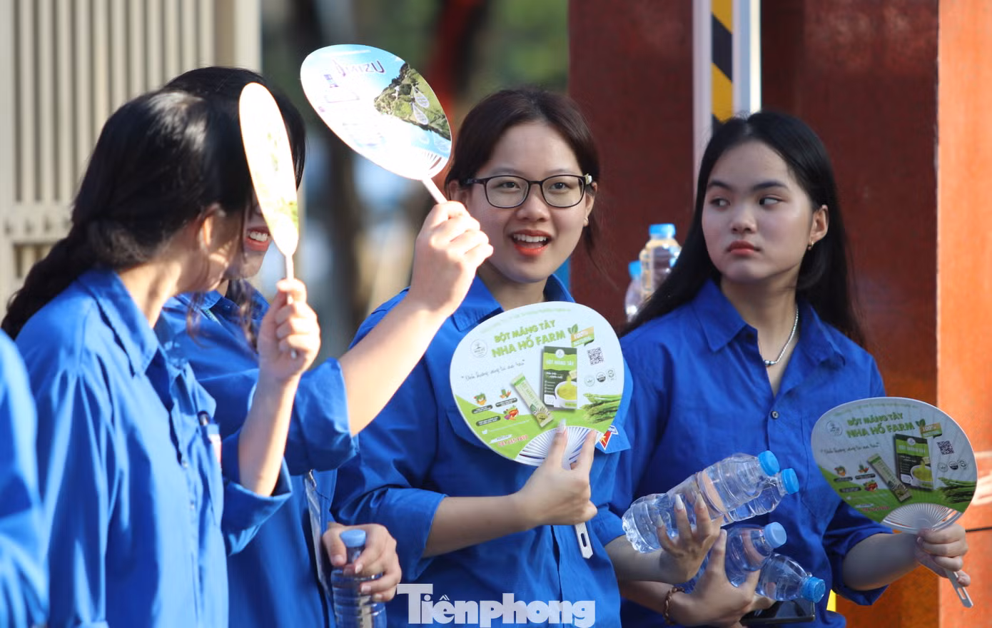 Những cô gái áo xanh trò chuyện trong lúc phát nước tiếp sức cho các sĩ tử ở điểm thi trường THPT chuyên Phan Bội Châu.