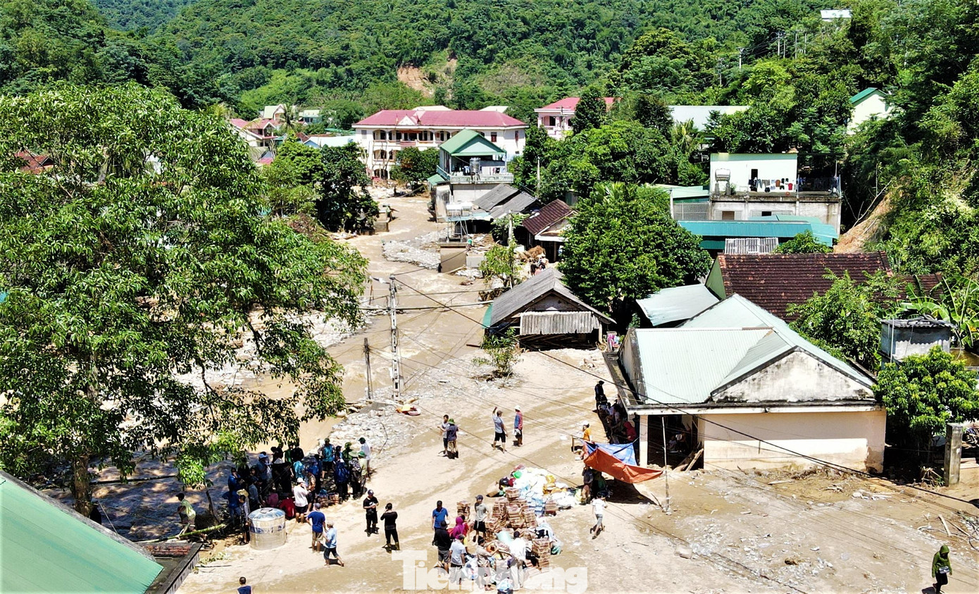 Với học sinh mầm non, do đặc thù độ tuổi của các em còn quá nhỏ, điểm trường chưa khắc phục được hư hỏng nên phòng dự kiến trước mắt sẽ mượn nhà dân học nhà sàn để dạy học cho học sinh. Trong ảnh là điểm trường mầm non ở xã Tà Cạ (góc phải) ngập trong lớp bùn dày.