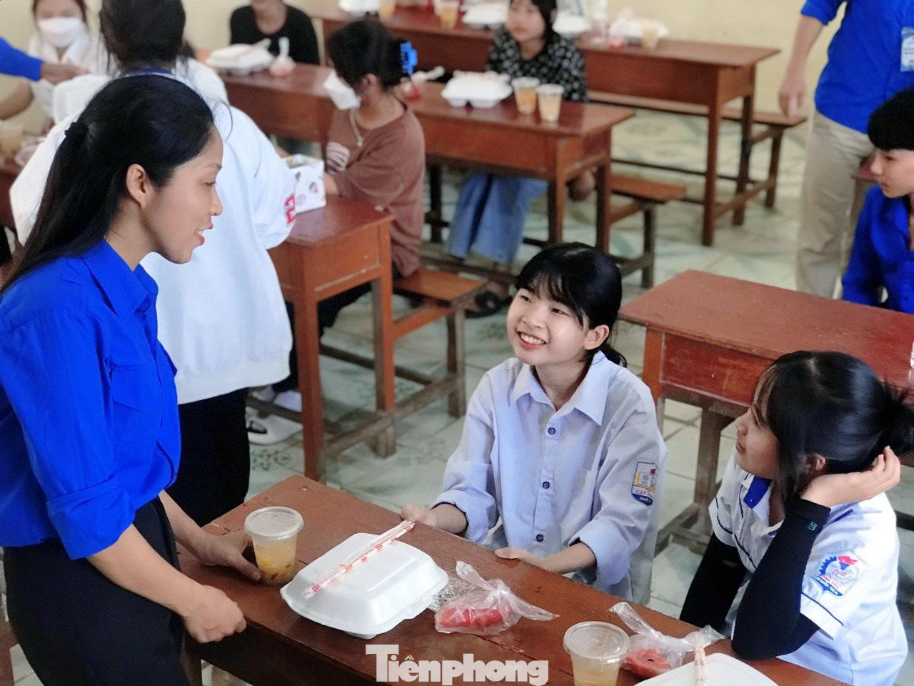 Nụ cười vui vẻ của các sĩ tử khi tiếp nhận suất cơm trưa từ các tình nguyện viên.