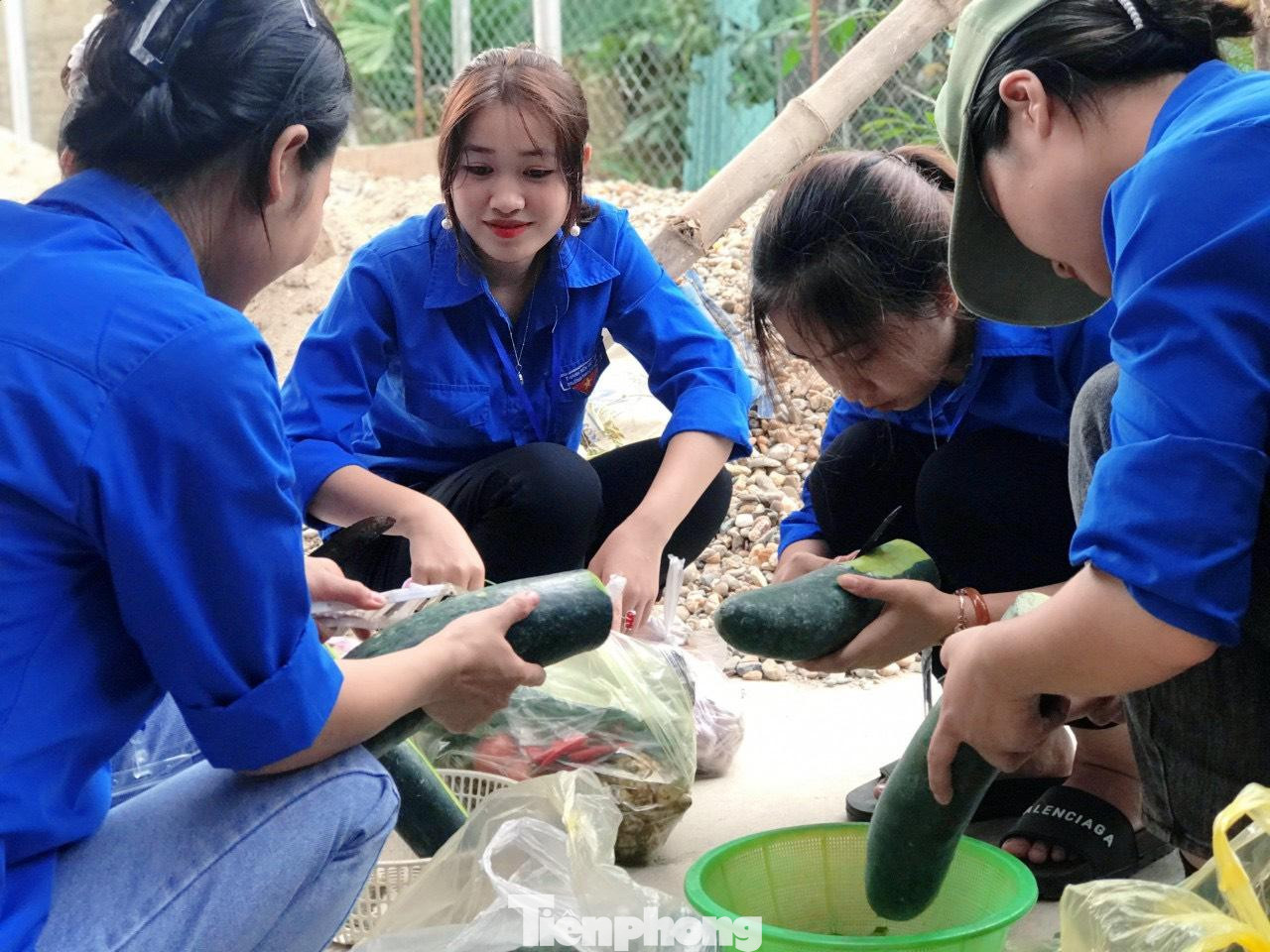 Những tình nguyện viên nữ khéo léo làm sạch rau, củ, quả chuẩn bị nấu ăn cho sĩ tử.