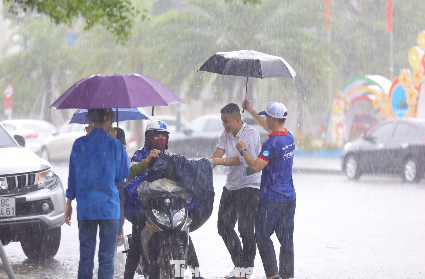 Các đoàn viên ra tận đường để đón thí sinh vào trường thi an toàn, tránh bị mưa ướt.