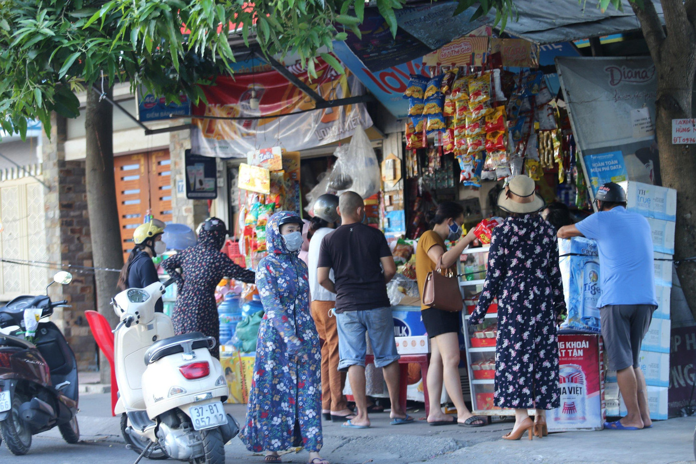 Cảnh người dân tập trung tại một quán tạp hóa để mua sắm.