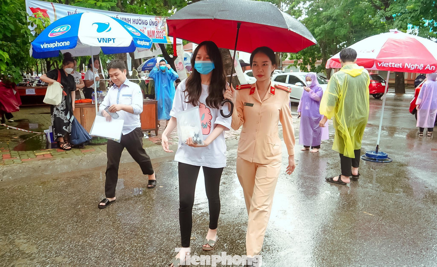 Thời tiết có mưa, các cán bộ, chiến sỹ CSGT còn tham gia hỗ trợ thí sinh vào phòng thi để không bị ướt.