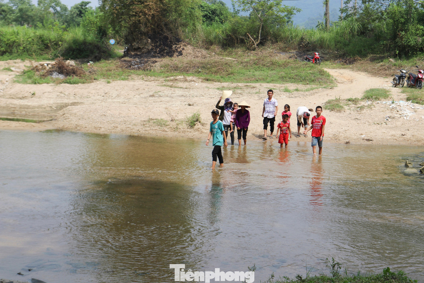 Chiều 30/7, trẻ em và người dân bản Ỏn, xã Tiên Kỳ, huyện Tân Kỳ (Nghệ An) đi qua suối để dự lễ khởi công công trình cầu dân sinh do báo Tiền Phong, Sở GD&amp;ĐT Nghệ An, Tỉnh đoàn Nghệ An tổ chức.