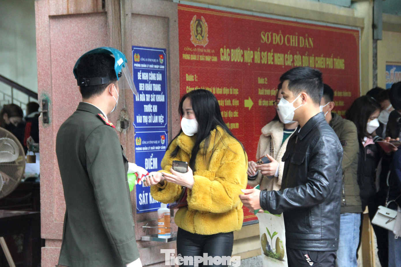 Lực lượng công an chia thành nhiều tổ đứng ở cổng ra vào phát số thứ tự, hướng dẫn người dân khai báo trực tuyến hoặc xịt nước sát khuẩn cho người dân trước khi vào làm thủ tục.