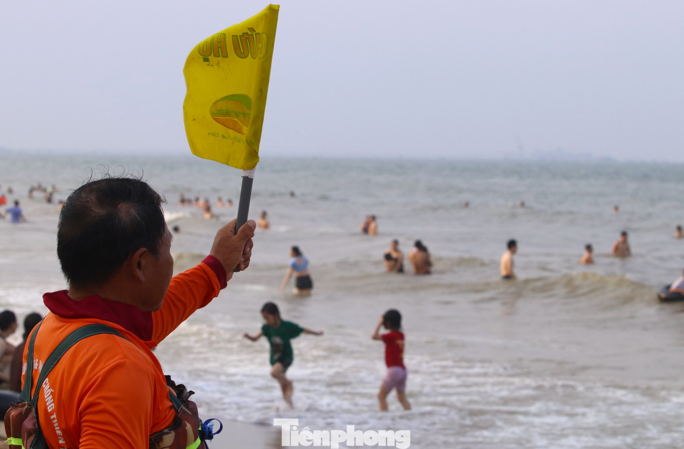 Đứng trên bờ, ông Tài Hùng (đội cứu hộ biển) liên tục phất cờ và thổi còi cảnh báo những du khách ra ngoài xa tắm. "Nếu thấy có người ra xa thì cảnh báo. Nếu có người đuối nước, gần thì mình bơi ra cứu. Xa thì báo cho cứu hộ, đội môtô nước chạy đến cứu ngay", ông Hùng nói.