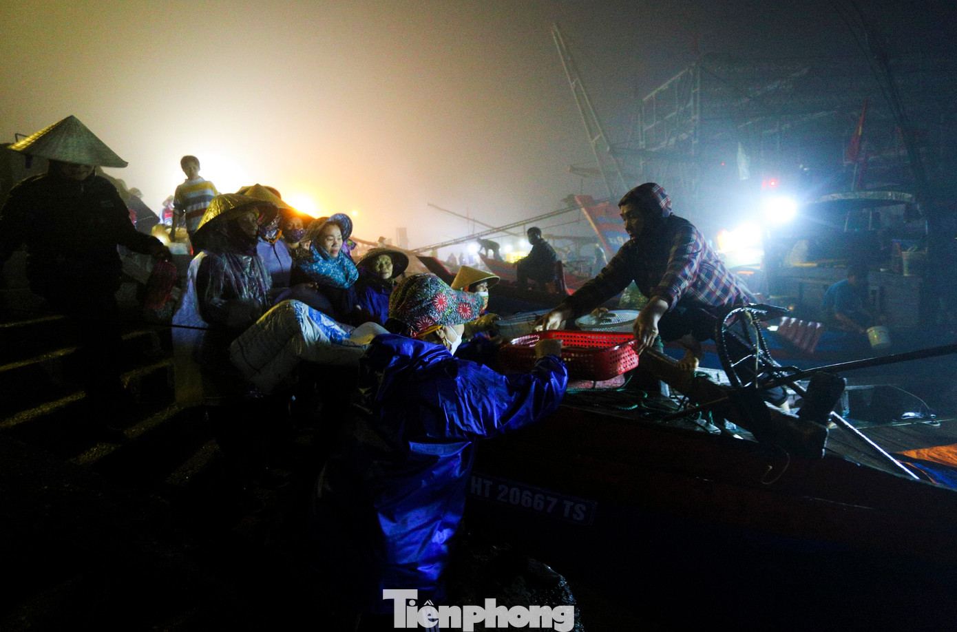 Dù là ngày Quốc tế phụ nữ 8/3 song với những phụ nữ này họ không chờ nhận hoa, quà từ người thân mà vẫn mang trên mình bộ quần áo mưa bạc màu, đầu đội nón lá, chân mang ủng, bên tay là đôi khay nhựa để chờ đội cá từ tàu lên cảng.