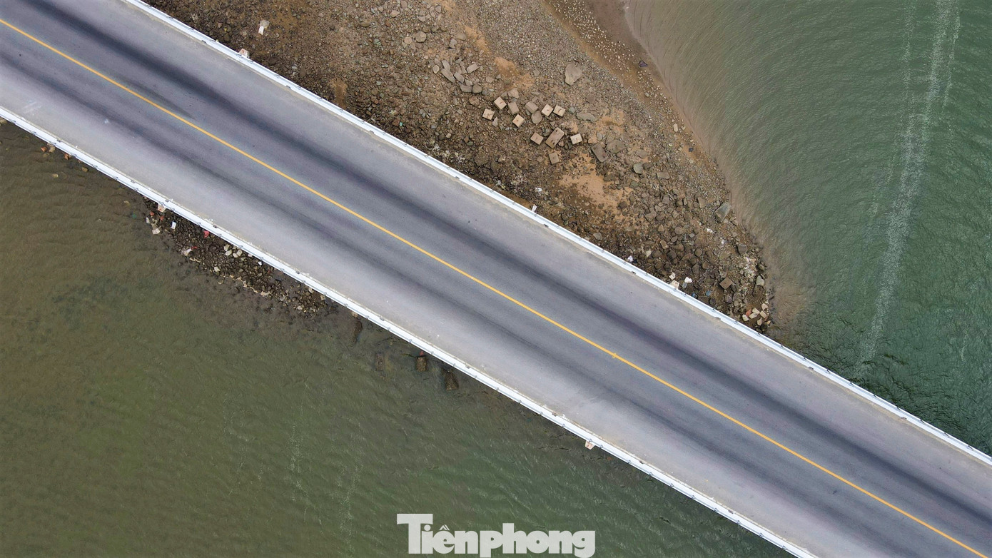 Nhìn từ trên cao, những khối đá, rác thải xây dựng nằm dưới chân cầu, thu hẹp dòng chảy.