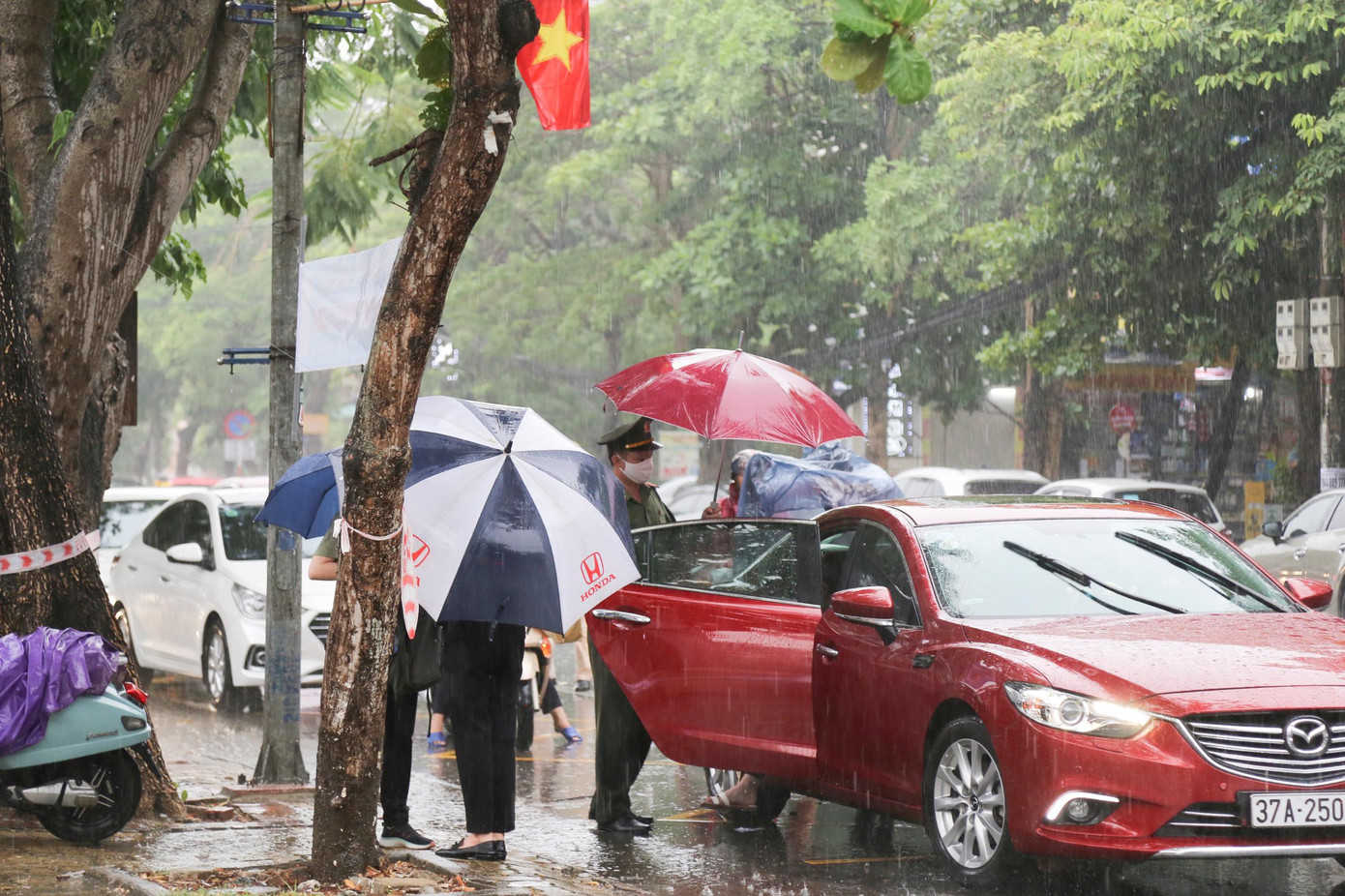Thời tiết Nghệ An có mưa lớn, lực lượng đoàn viên của Đoàn công an tỉnh Nghệ An tiếp ứng thí sinh từ khi xuống xe. Trong ảnh: Đại úy Nguyễn Đình Khánh - Bí thư Đoàn công an tỉnh Nghệ An đón thí sinh vào điểm thi.