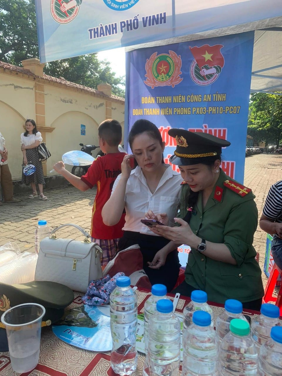 Thấy có điểm hỗ trợ cài đặt tài khoản định danh điện tử, nhiều phụ huynh đưa con đi thi đến nhờ các cán bộ công an hỗ trợ.