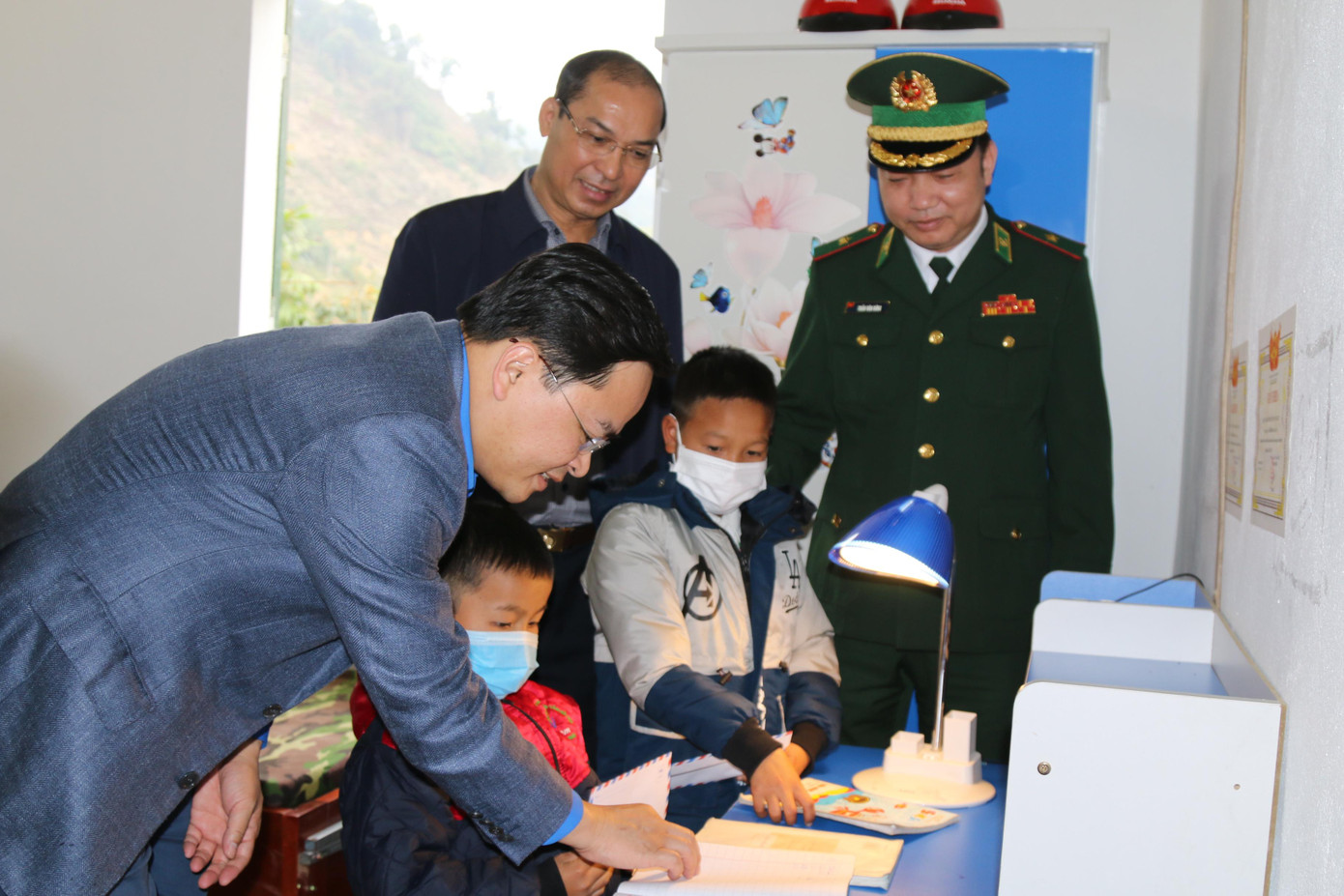 Anh Nguyễn Anh Tuấn động viên hai con nuôi của Đồn biên phòng tại góc học tập của các cháu.