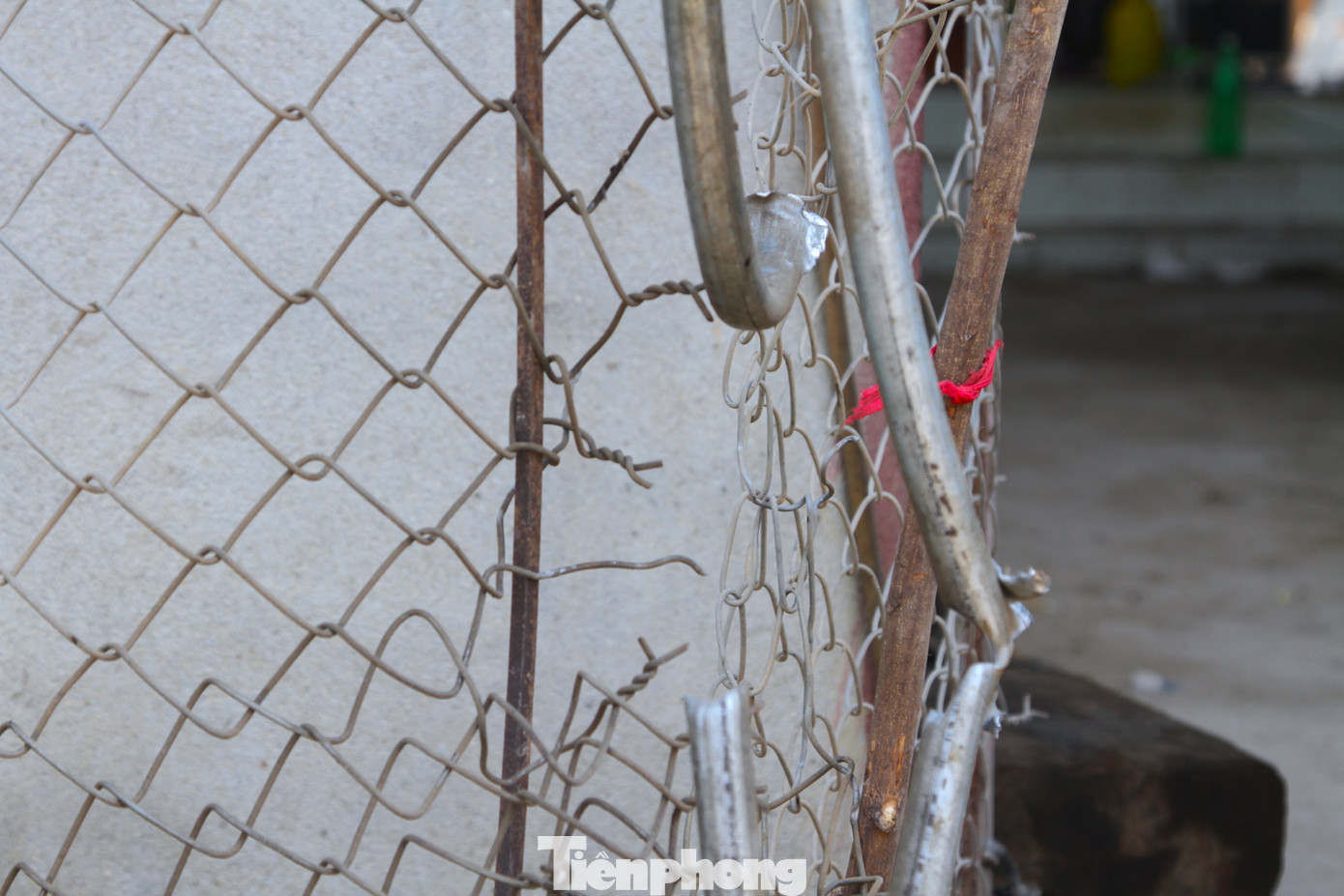 Phần tường gara bị vỡ nhiều điểm. Cánh cổng gara làm từ sắt và lưới bị các mảnh vỡ cắt đứt, thủng.