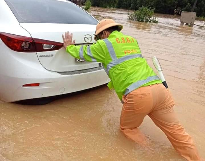 Chiến sĩ cảnh sát giao thông hỗ trợ người dân đưa xe ô tô qua đoạn đường bị ngập sâu. Chiến sĩ cảnh sát giao thông hỗ trợ người dân đưa xe ô tô qua đoạn đường bị ngập sâu.