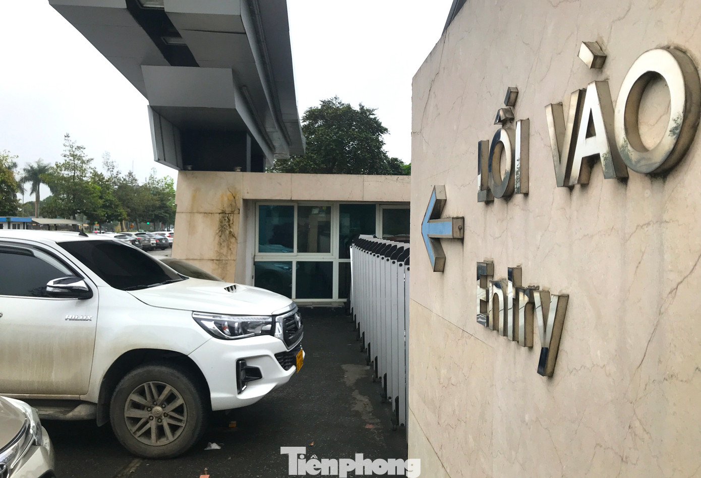 Lối vào cổng chính bệnh viện đã bị chắn rào và cho đỗ ô tô để thu phí thay vì mở cửa để đi cho rộng rãi.