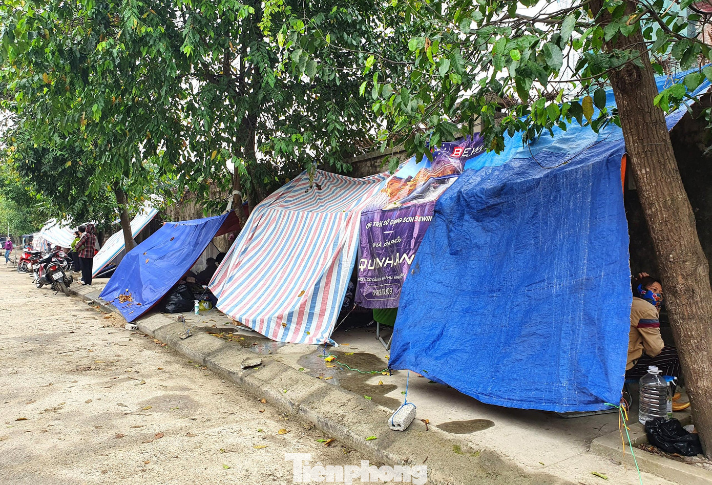 Phía trước cổng trung tâm, nhiều người dân dựng các túp lều tạm bợ để trú ẩn, chờ đợi thông tin của người thân đang điều trị bên trong.