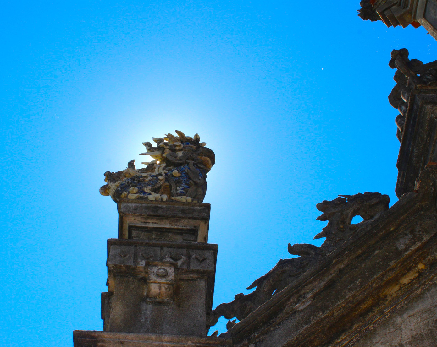 Tầng 2 có diện tích sàn gần 9m2, cũng được tạo nên từ 4 trụ lớn. Mặt trước và sau tương đối giống nhau. Các trụ giật cấp, liên kết tạo thành 2 cửa hình tròn được trang trí hình tre, trúc, hoa dây, họa tiết hình học, cuốn thư. Tầng trên cùng mang tính cách điệu. Các mái ngói của nghi môn đều cuốn đầu đao cong vút với những hình rồng mềm mại, uyển chuyển, đậm chất phương Đông. Tầng 1 gắn với 2 trụ biểu bằng các bức tường xuyên hoa, điểm chữ “thọ”, phía trên đắp nổi 2 con nghê, 2 con rồng đang chầu về chính môn. Tầng 2 có diện tích sàn gần 9m2, cũng được tạo nên từ 4 trụ lớn. Mặt trước và sau tương đối giống nhau. Các trụ giật cấp, liên kết tạo thành 2 cửa hình tròn được trang trí hình tre, trúc, hoa dây, họa tiết hình học, cuốn thư. Tầng trên cùng mang tính cách điệu. Các mái ngói của nghi môn đều cuốn đầu đao cong vút với những hình rồng mềm mại, uyển chuyển, đậm chất phương Đông. Tầng 1 gắn với 2 trụ biểu bằng các bức tường xuyên hoa, điểm chữ “thọ”, phía trên đắp nổi 2 con nghê, 2 con rồng đang chầu về chính môn.