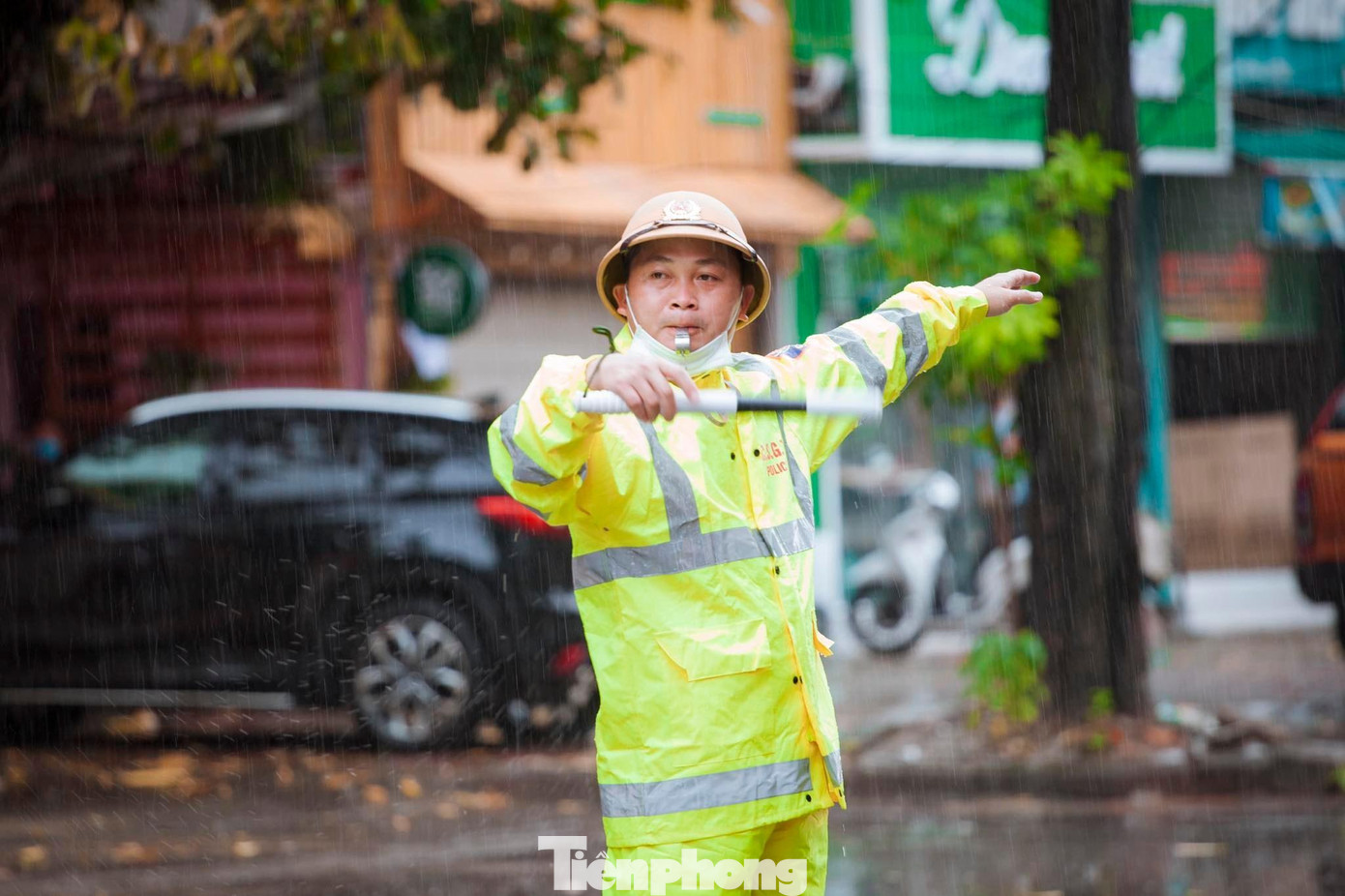 Để đảm bảo an ninh trật tự cũng như hỗ trợ thí sinh, phụ huynh trước và sau Kỳ thi tốt nghiệp THPT năm 2022, Công an thành phố Vinh đã huy động lực lượng túc trực tại các điểm thi và các điểm giao thông trọng yếu. Trong ảnh: Đại úy Đặng Hữu Hạnh - Đội CSGT - TT Công an thành phố Vinh đội mưa phân làn giao thông cho phụ huynh, thí sinh trong ngày 7/7.