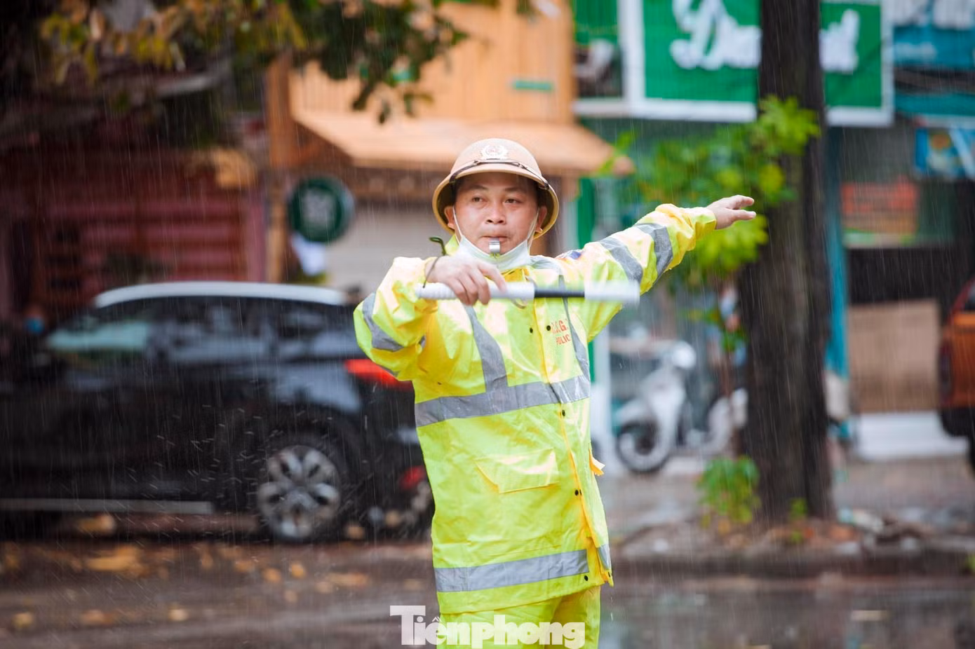 Để đảm bảo an ninh trật tự cũng như hỗ trợ thí sinh, phụ huynh trước và sau Kỳ thi tốt nghiệp THPT năm 2022, Công an thành phố Vinh đã huy động lực lượng túc trực tại các điểm thi và các điểm giao thông trọng yếu. Trong ảnh: Đại úy Đặng Hữu Hạnh - Đội CSGT - TT Công an thành phố Vinh đội mưa phân làn giao thông cho phụ huynh, thí sinh trong ngày 7/7.
