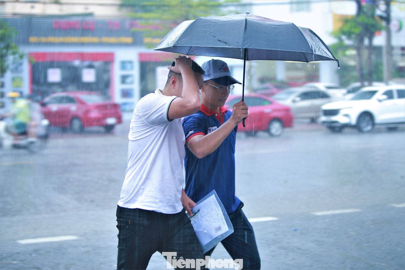 Cơn mưa lớn khiến cả tình nguyện viên và thí sinh cũng bị ướt.