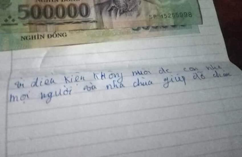 Tiền và tờ giấy có ghi mấy dòng chữ được đặt trên người cháu bé ở sân chùa.