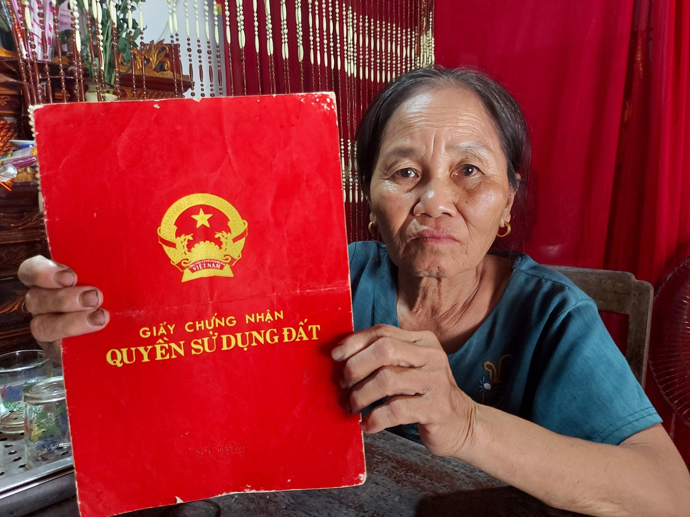 Bà Nguyễn Thị Liên cầm trên tay sổ đỏ hợp pháp do UBND huyện Quỳnh Lưu cấp cho vợ chồng bà năm 1995 tại thửa đất số 104. Bà Nguyễn Thị Liên cầm trên tay sổ đỏ hợp pháp do UBND huyện Quỳnh Lưu cấp cho vợ chồng bà năm 1995 tại thửa đất số 104.