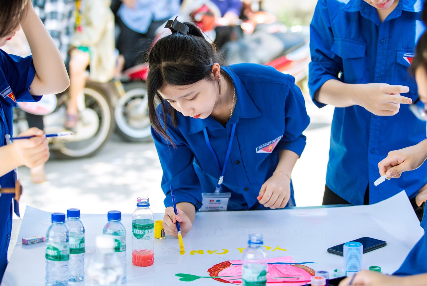 Những &quot;bóng hồng áo xanh&quot; trổ tài vẽ tranh cổ vũ tinh thần cho các sĩ tử. Ảnh: Rạng Đông.