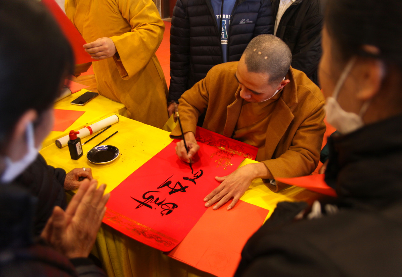 Thầy Minh Cảnh - Trụ trì chùa Bát Nhã (thị xã Hoàng Mai) cho chữ du khách ngay trong chính điện của chùa. Rất đông du khách đứng xung quanh để mong được thầy cho chữ ngày đầu năm mới.