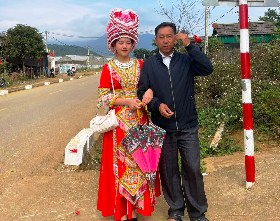 Nữ sinh người Mông Thò Ý Cu chụp hình cùng bố tại quê nhà (ảnh NVCC)