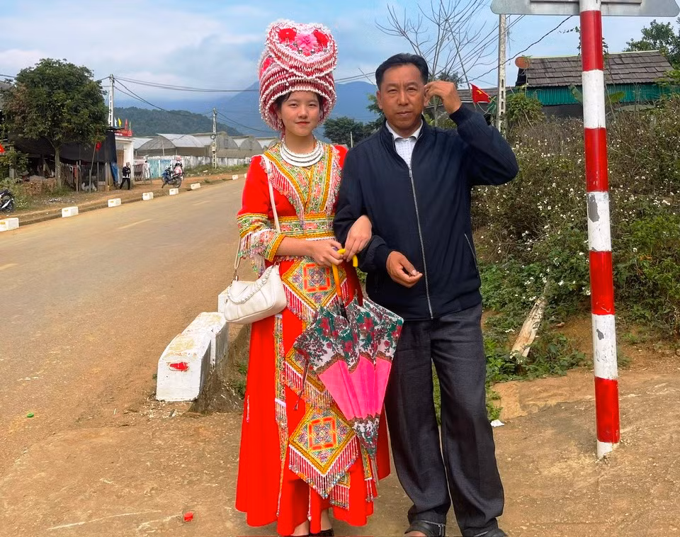 Nữ sinh người Mông Thò Ý Cu chụp hình cùng bố tại quê nhà (ảnh NVCC)