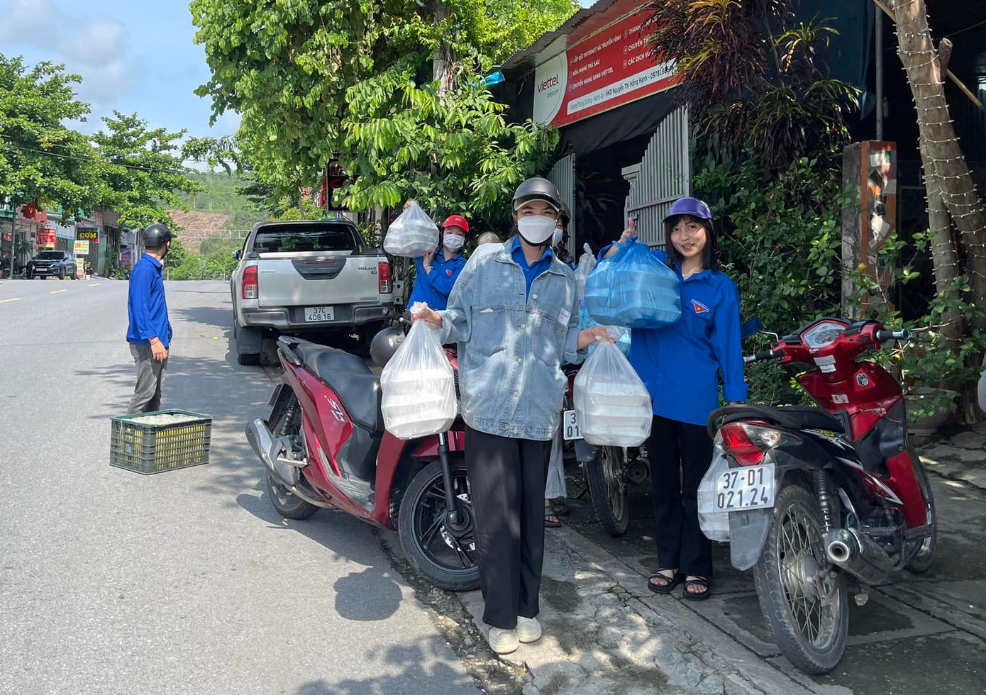 Những bạn đoàn viên tình nguyện đội nắng mang cơm để đưa cho các thí sinh sau buổi thi sáng 5/6.