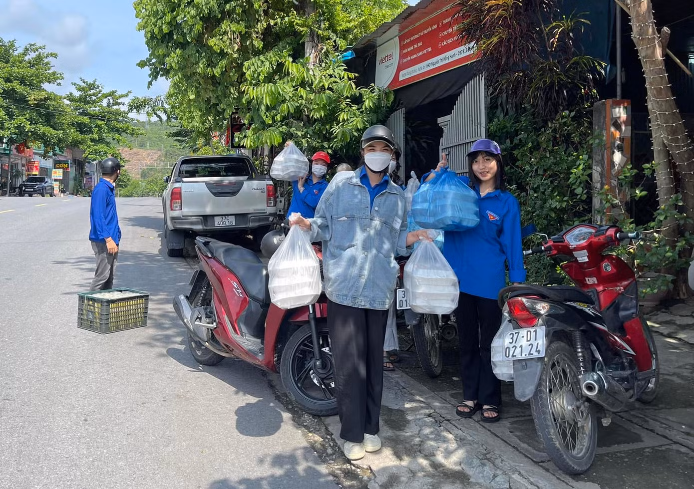 Những bạn đoàn viên tình nguyện đội nắng mang cơm để đưa cho các thí sinh sau buổi thi sáng 5/6.