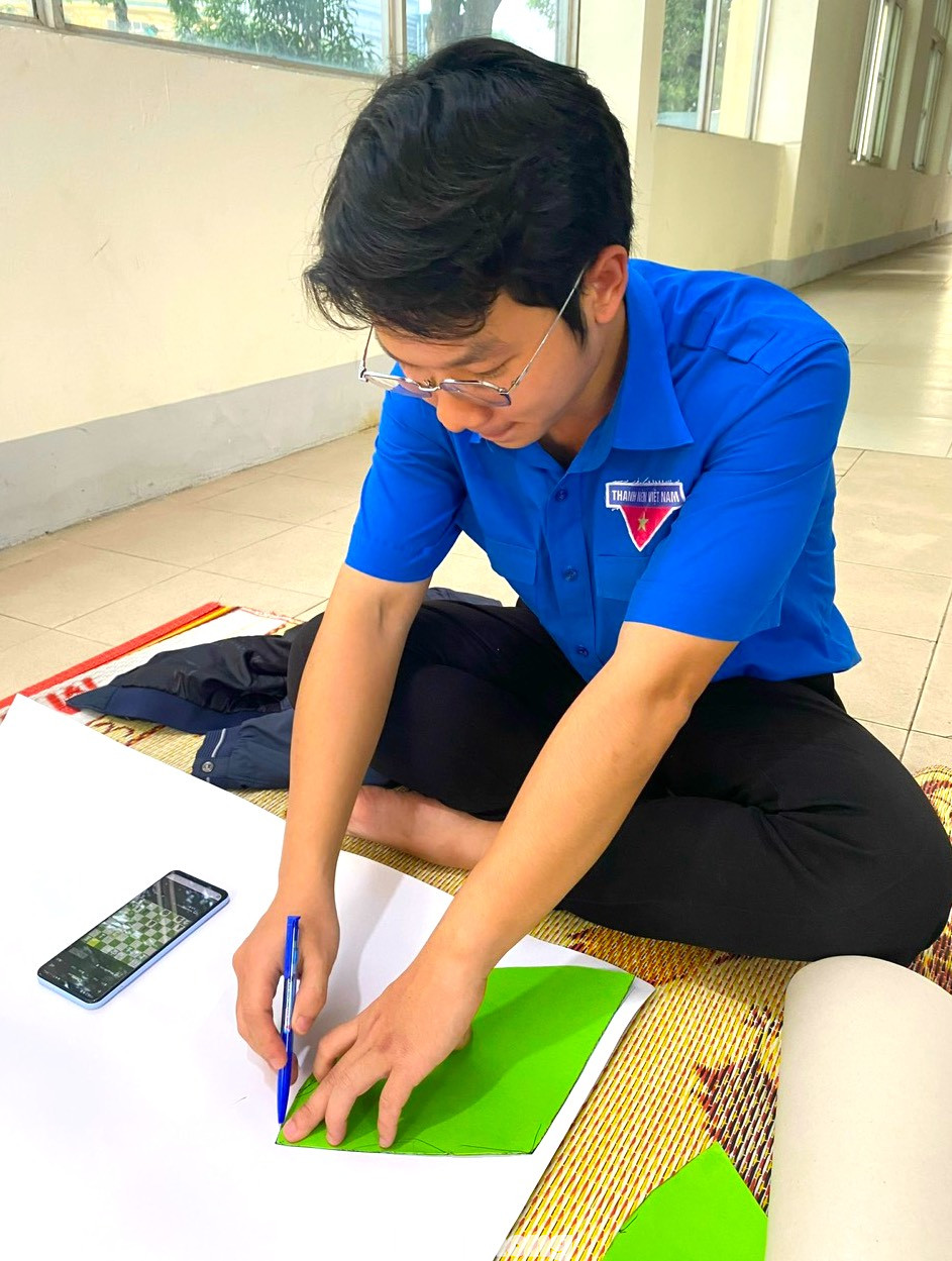 Để làm ra được cây thông Noel đẹp, bắt mắt, các đoàn viên phải tỉ mỉ đo kích thước rồi cắt những tấm bìa cứng làm khung.