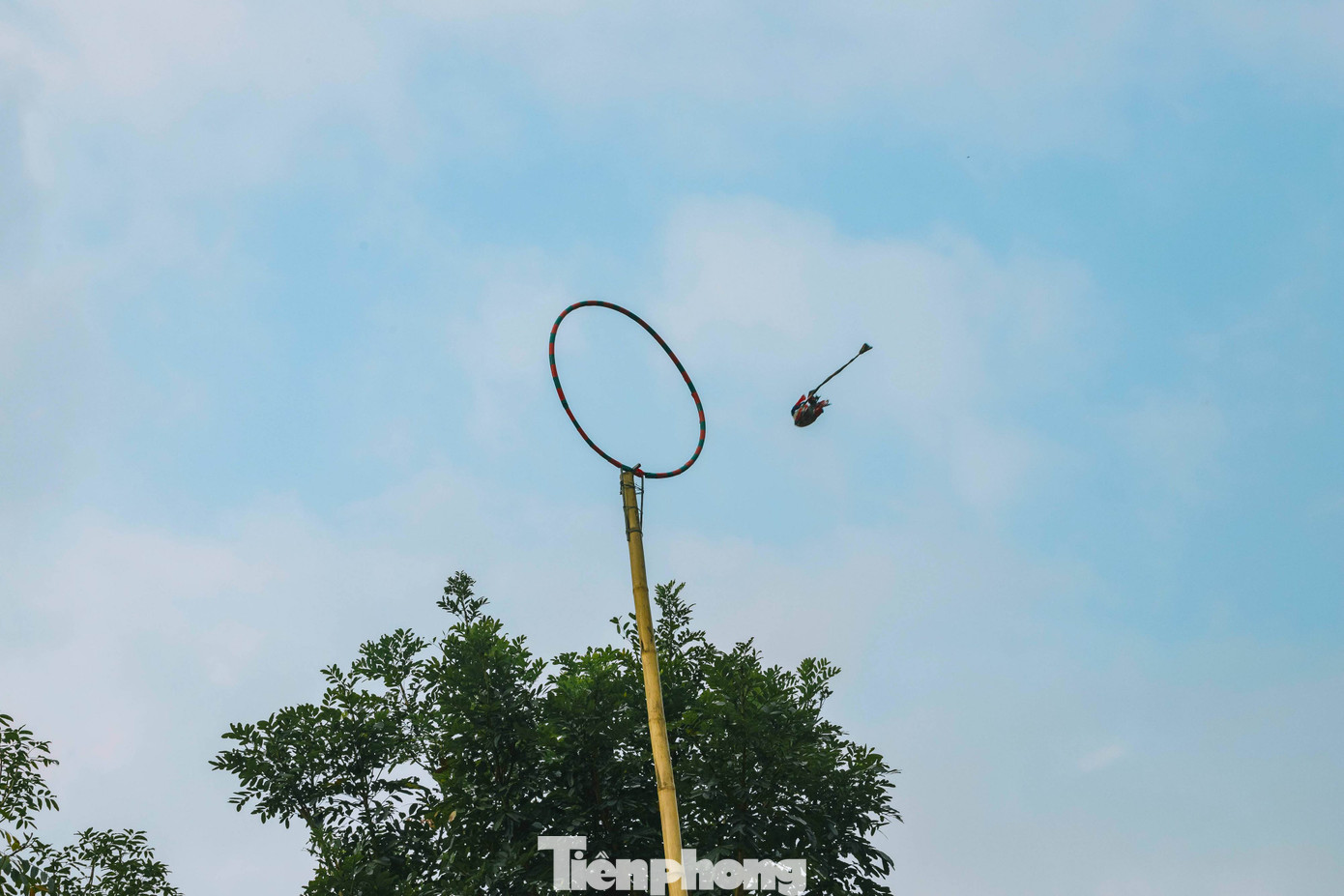 Người chơi cầm gần cuối đoạn dây vải quay quả còn vài vòng theo chiều kim đồng hồ rồi mới tung lên để quả còn bay lọt qua vòng tròn là thắng cuộc. Ai ném được còn lọt qua vòng trên cao được xem như là người sẽ có nhiều may mắn. (Ảnh: Rạng Đông). Người chơi cầm gần cuối đoạn dây vải quay quả còn vài vòng theo chiều kim đồng hồ rồi mới tung lên để quả còn bay lọt qua vòng tròn là thắng cuộc. Ai ném được còn lọt qua vòng trên cao được xem như là người sẽ có nhiều may mắn. (Ảnh: Rạng Đông).