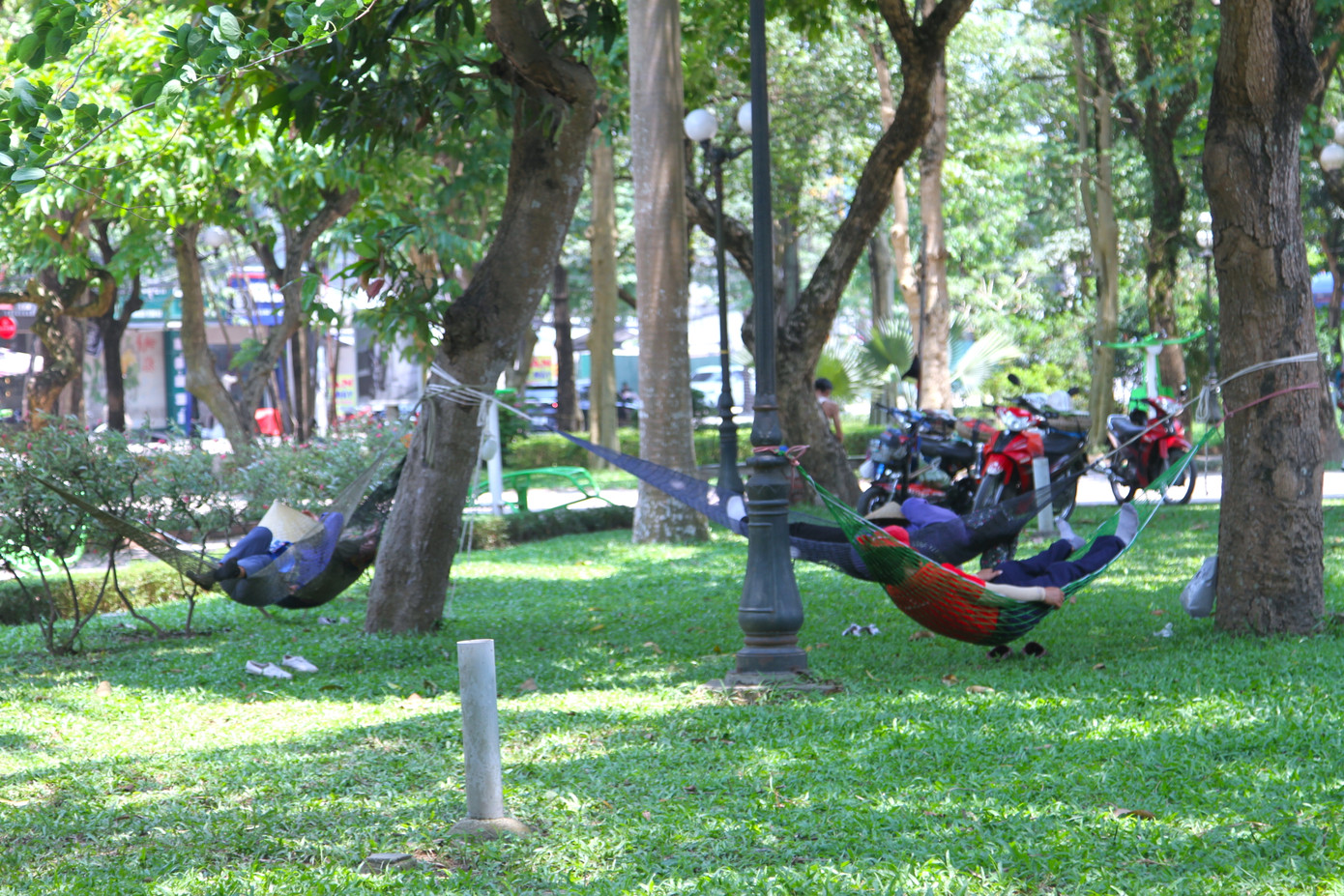 Giờ nghỉ trưa, nhiều lao động tìm đến các công viên có cây xanh như Công viên Nguyễn Tất Thành để mắc võng nằm dưới bóng cây.