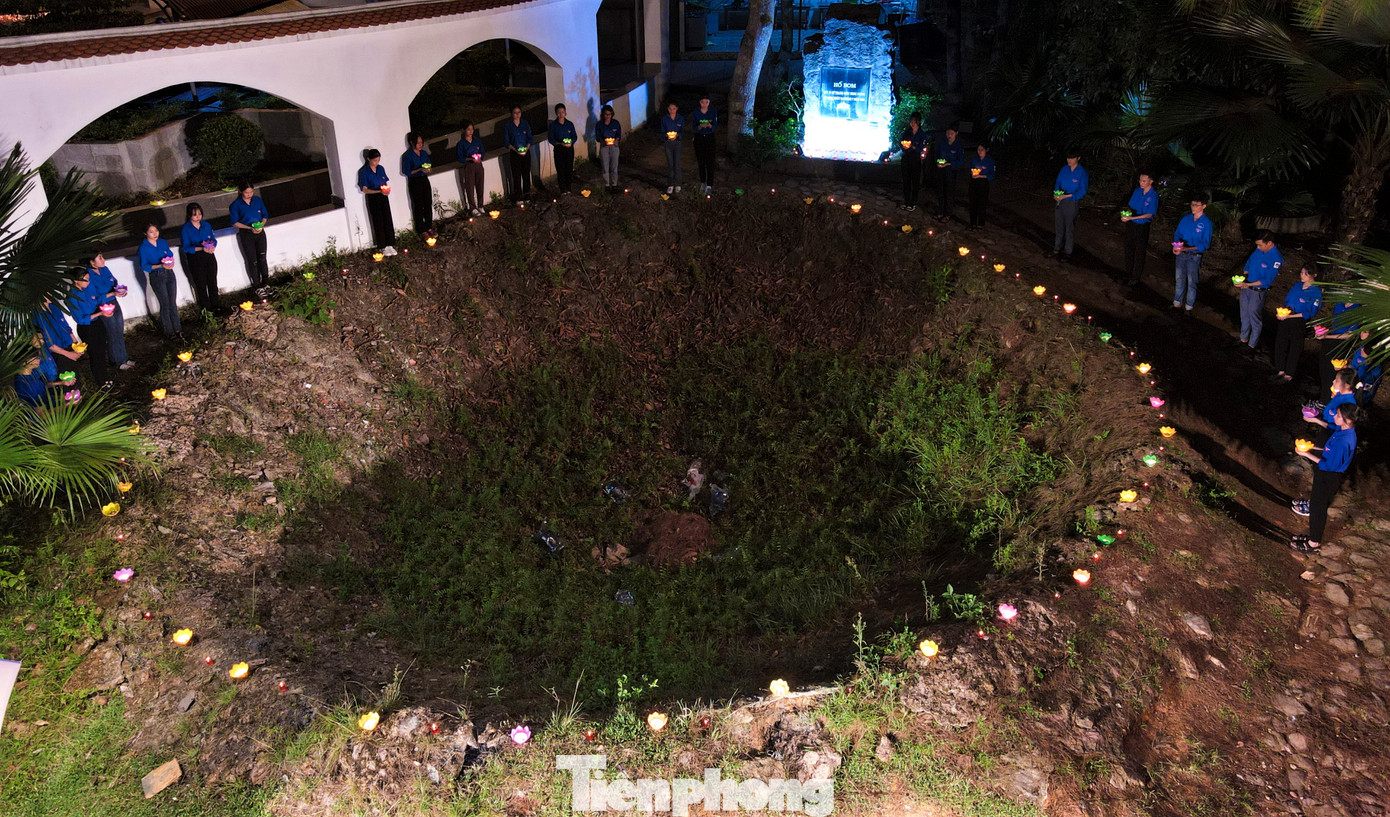 Đoàn viên thanh niên cầm trên tay những ngọn nến, đứng quanh hố bom nơi 10 nữ anh hùng TNXP hy sinh để bày tỏ lòng thành kính, tưởng nhớ.