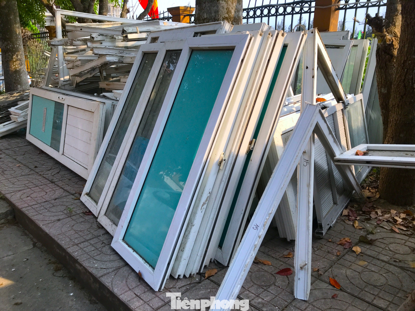 Khung cửa kính, song sắt cửa sổ được tháo dỡ từ tòa nhà cũ được để trong khuôn viên ủy ban xã.