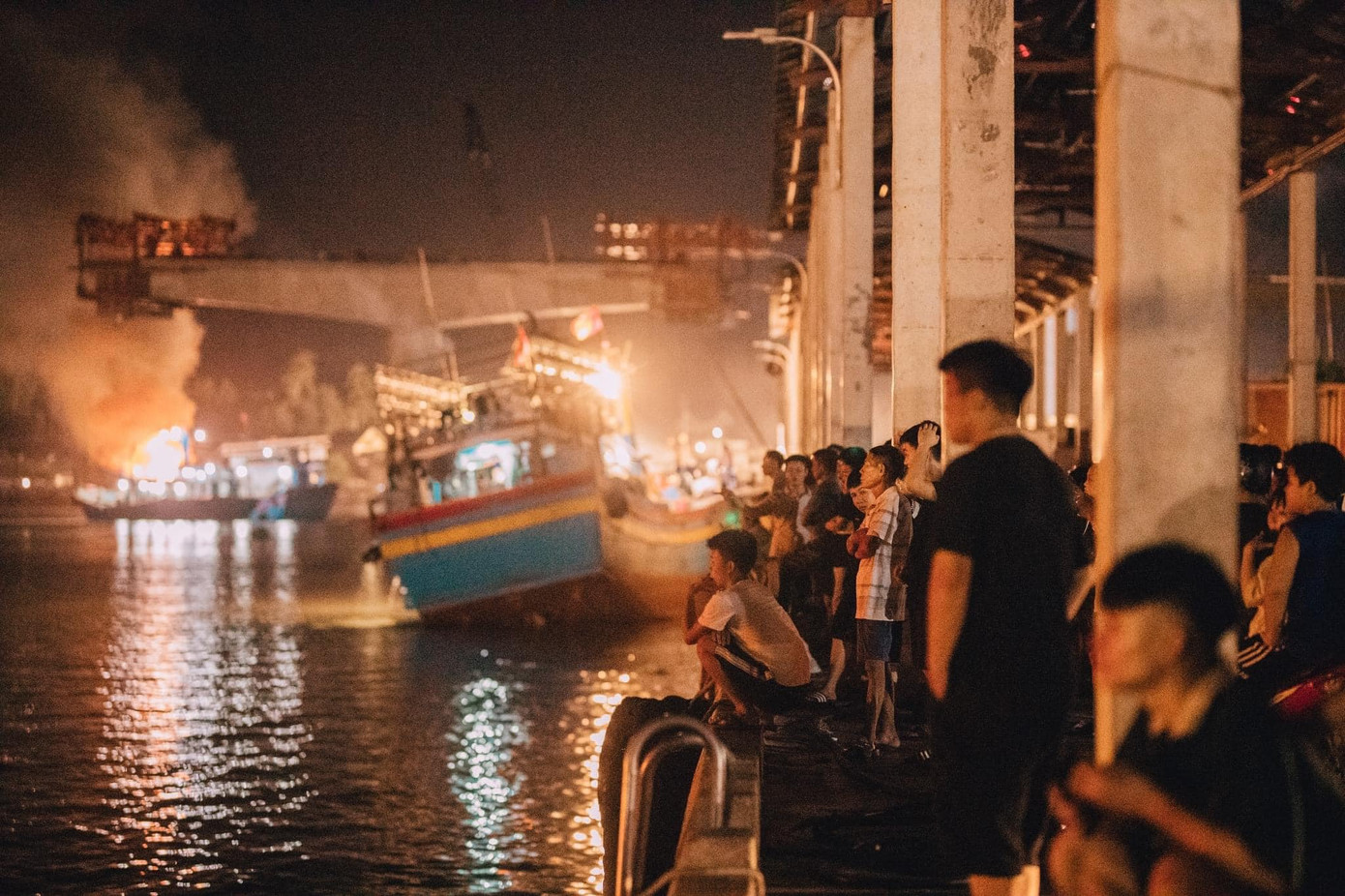 Phát hiện đám cháy, người dân xung quanh liền hô hoán, trình báo chính quyền địa phương đồng thời dùng các phương tiện tại chỗ để dập lửa cháy tàu. Ảnh: Mạnh Tino.