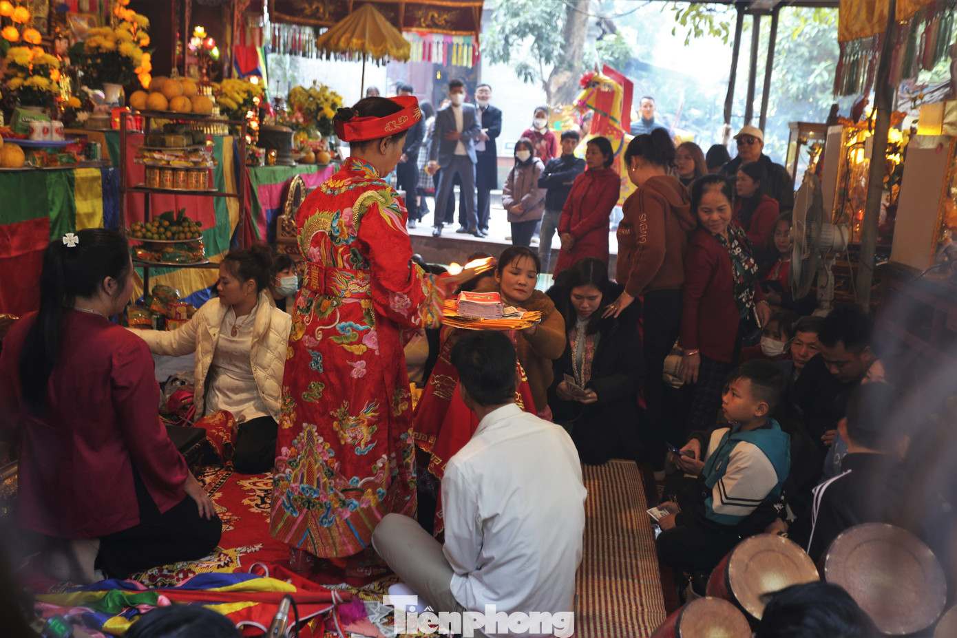 Phía ngoài sân chầu có đội ngũ hầu đồng, khấn thuê và tập trung đông đảo người tham gia.