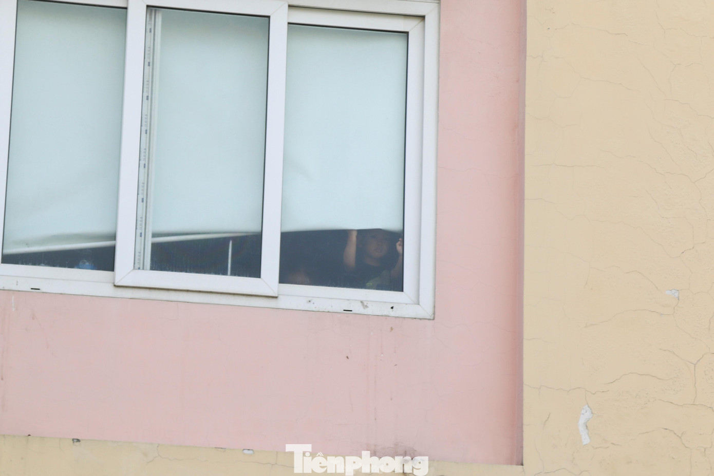 Sau ô cửa sổ, bệnh nhân nhi mắc COVID-19 nhìn ra ngoài với ánh mắt buồn bã, trông mong.