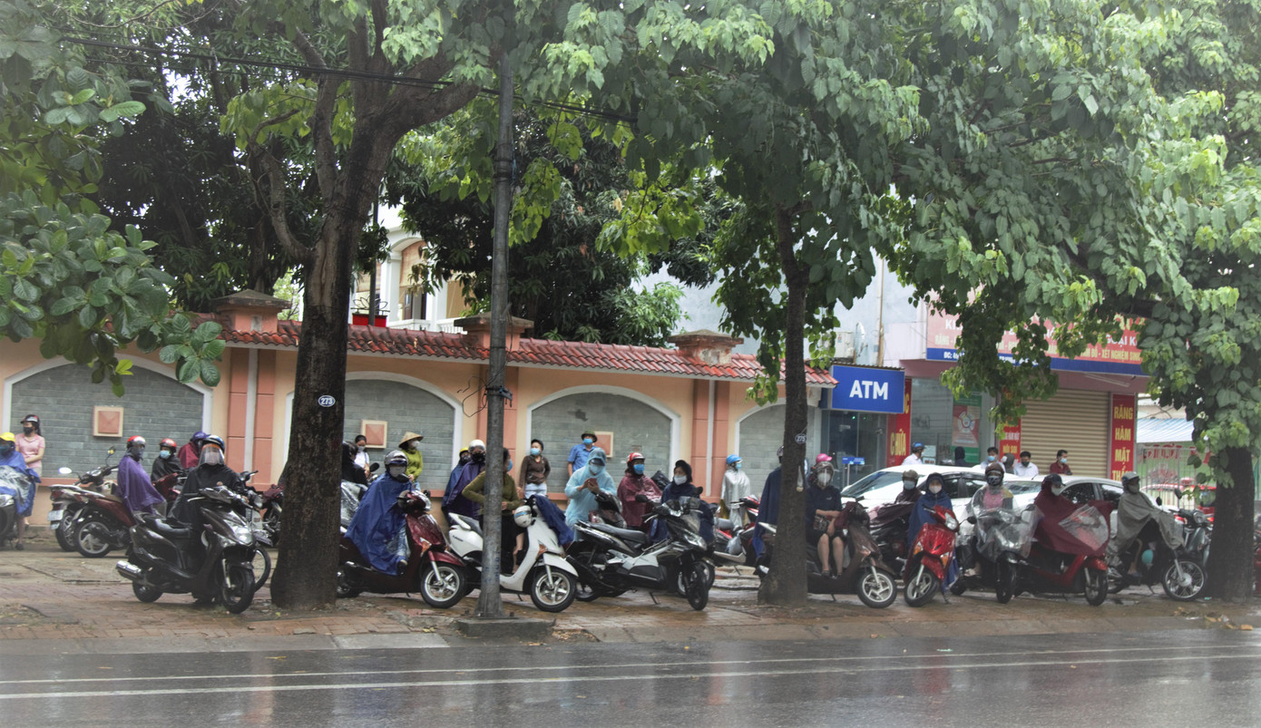 Sáng 7/7, trong khi thí sinh vào thực hiện bài thi môn Ngữ Văn, bên ngoài điểm thi, phụ huynh chờ đợi.