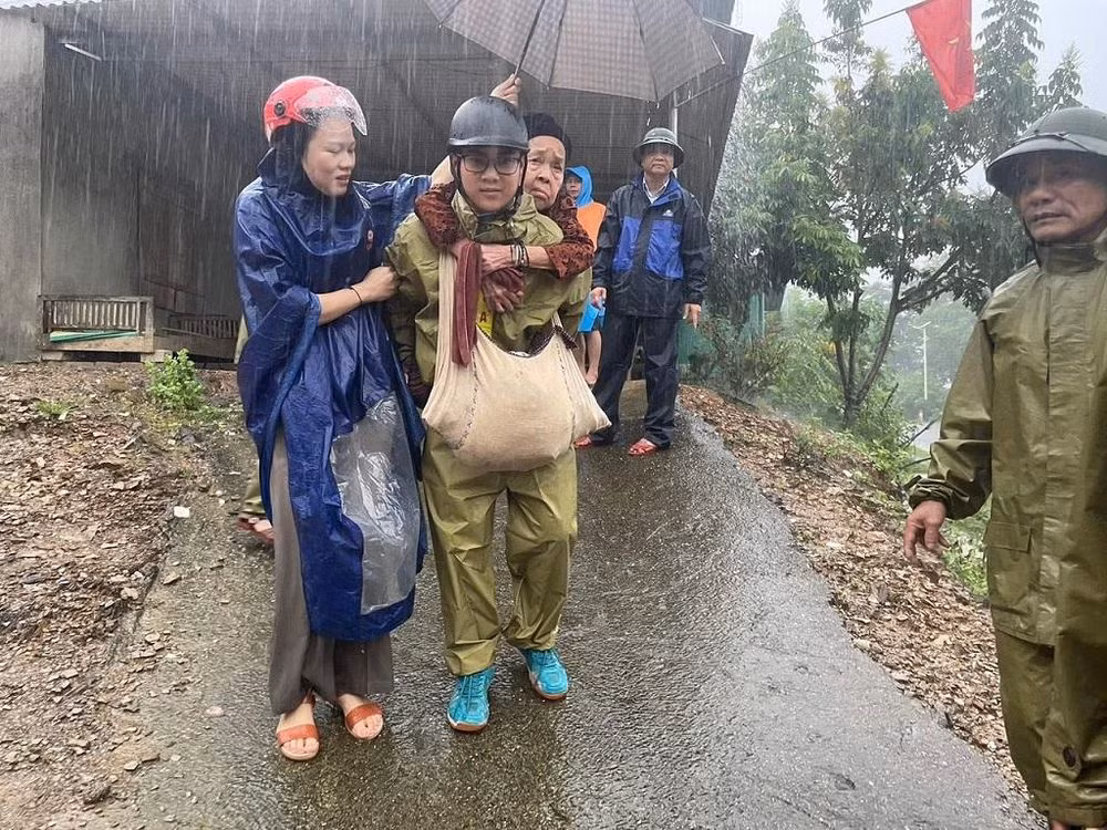 Lực lượng đoàn viên, thanh niên hỗ trợ đưa người lớn tuổi khỏi khu vực nguy cơ bị sạt lở.