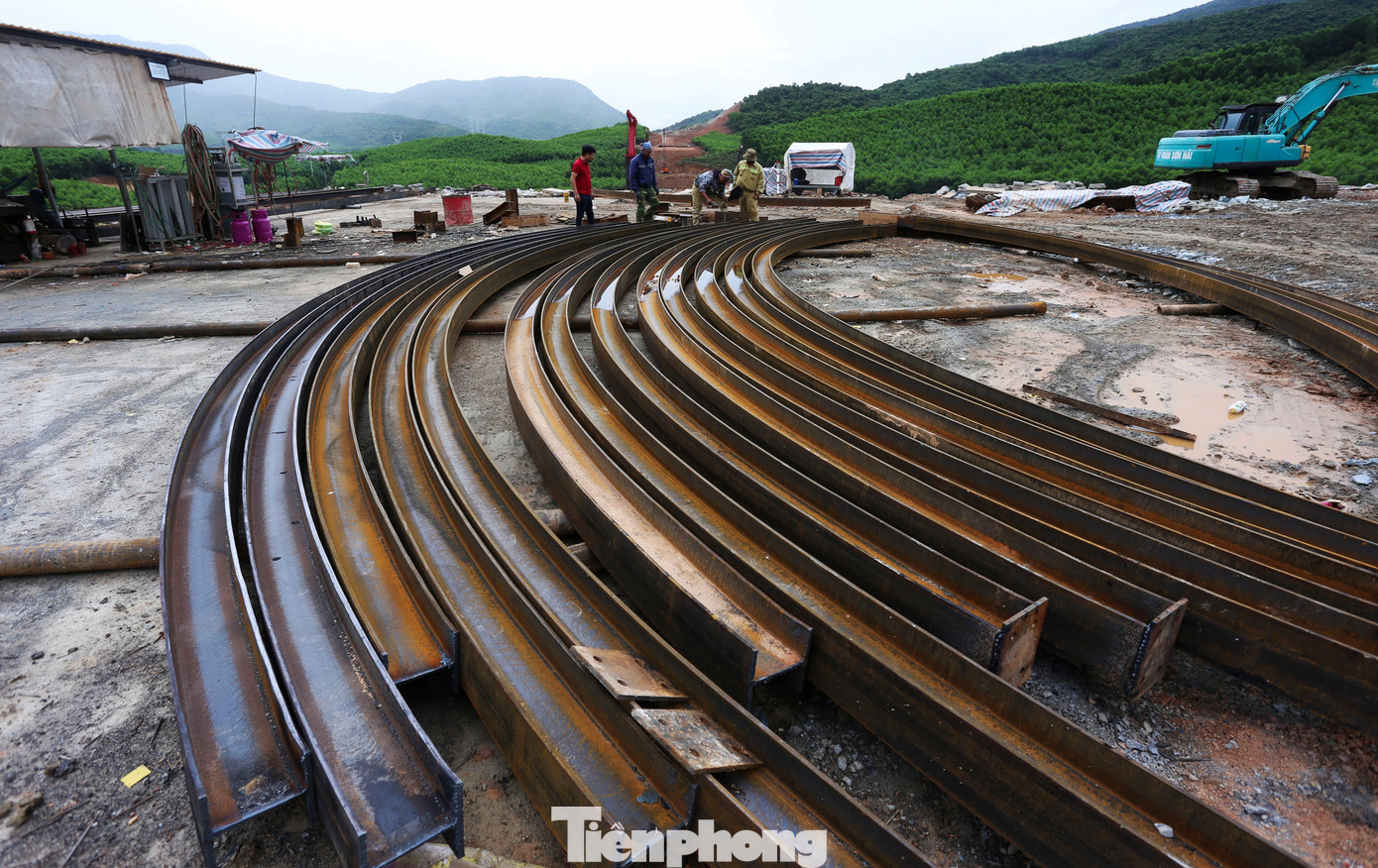 Bên ngoài, các công nhân đang hàn cấu kiện thép vòm, đỡ trong quá trình thi công hầm xuyên núi.