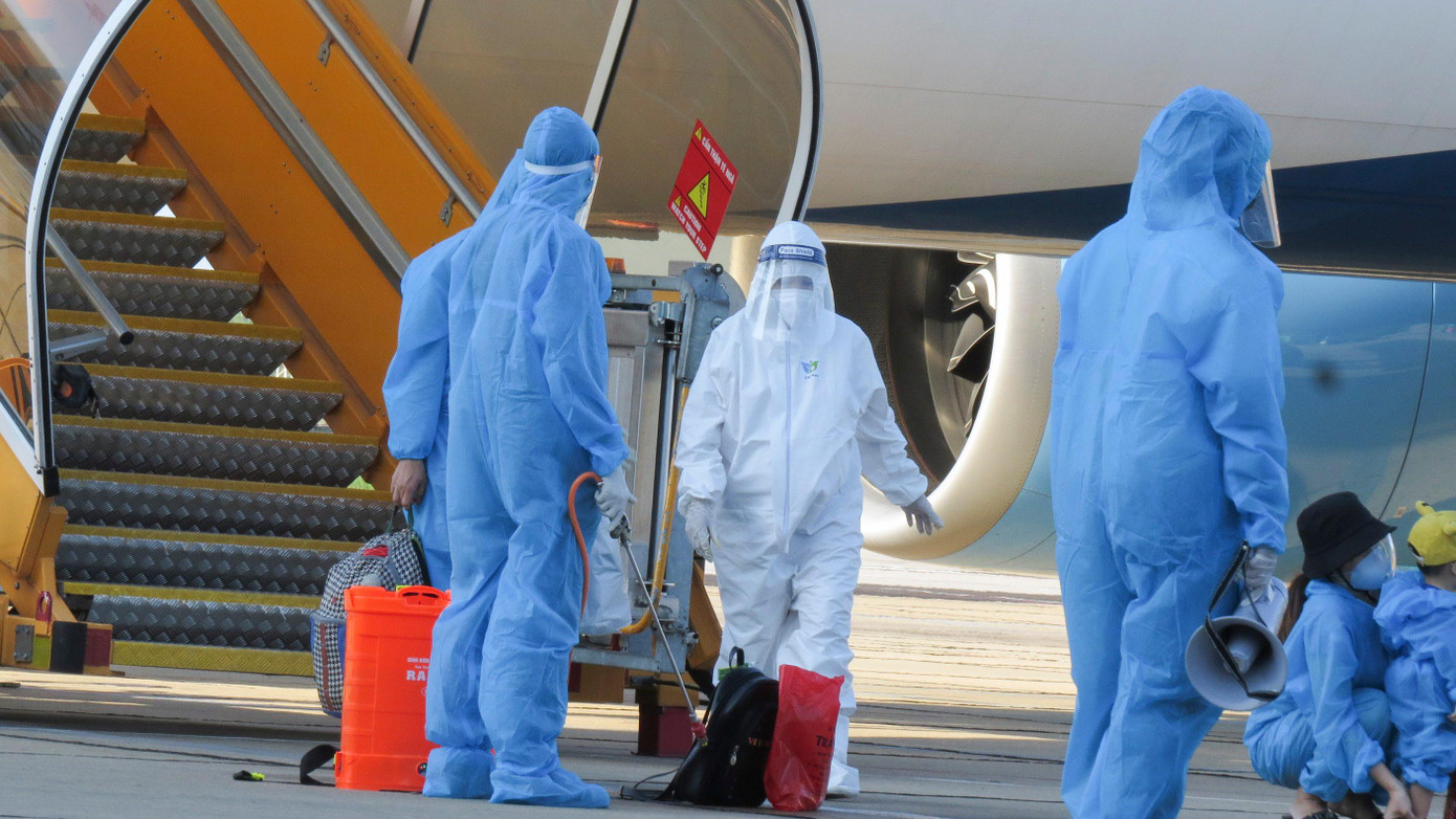 Những công dân này được nhân viên y tế, an ninh sân bay phun khử khuẩn hành lý trước khi lên xe về khu vực cách ly tập trung.