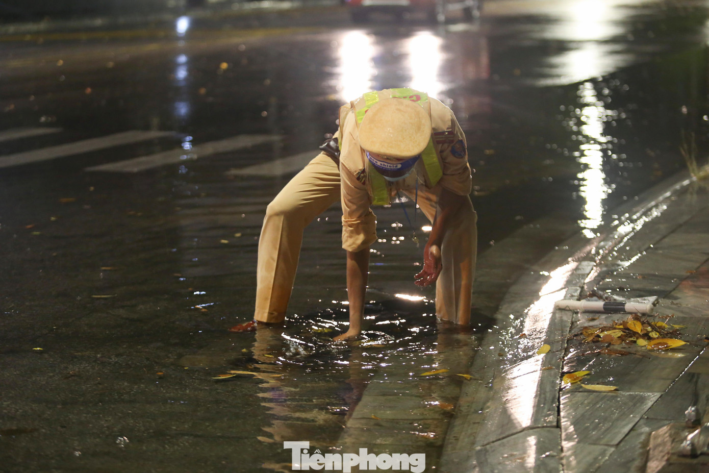 Sau trận mưa lớn, nhiều tuyến đường ngập nước, lực lượng làm nhiệm vụ tại chốt phải vớt rác, khơi thông dòng chảy, tránh ngập úng trên đường.